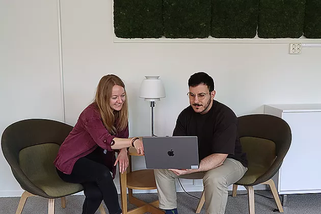 Two people looking at a laptop. Photo.