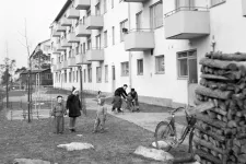 Kids standing outside an apartment building. Black and white photo.