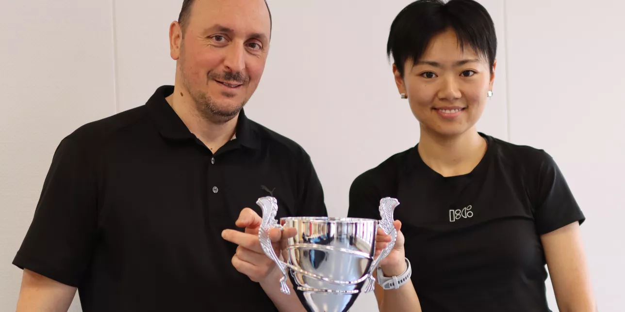 Photo of a man and a woman with a winner's cup.