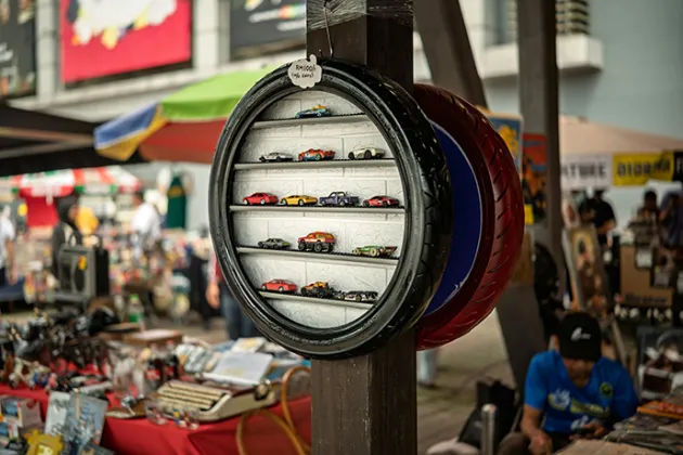 A box with a glass front, with toy cars behind it, at a flea market