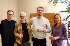Fyra leende personer, Johan Jönsson med handledare. Foto.