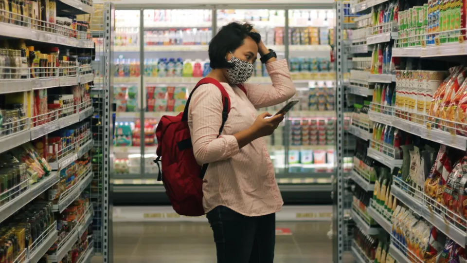 Woman looking at supermarket shelves. Photo.
