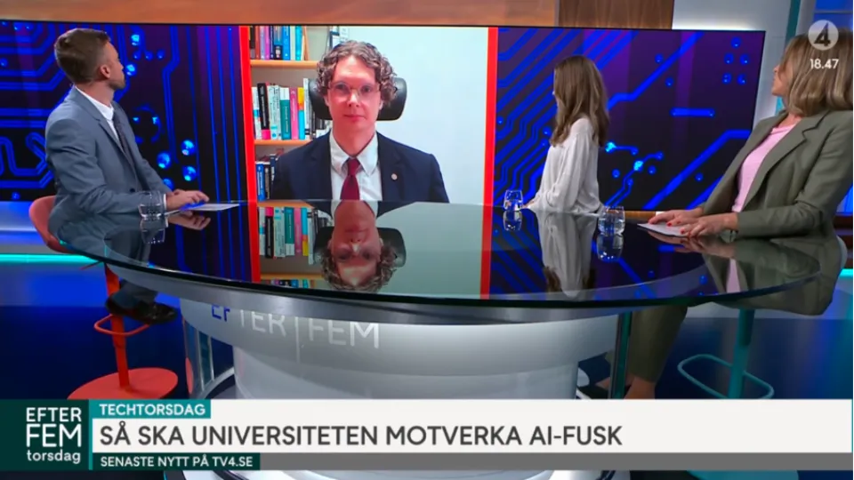 Björn Svensson is projected on a screen between three hosts during a TV broadcast. 