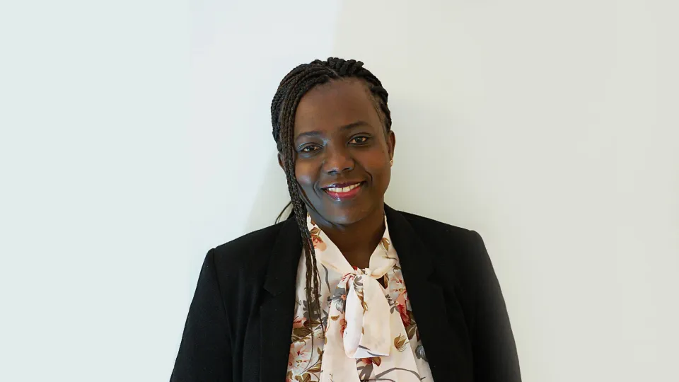 Portrait photograph of Betty Saenyi, smiling at the camera. 