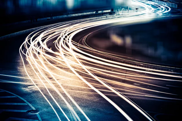 Traffic by night, where the headlights look like stretches along the road. Photo.