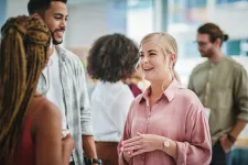 Mingle with people talking in a light room. Photo. 