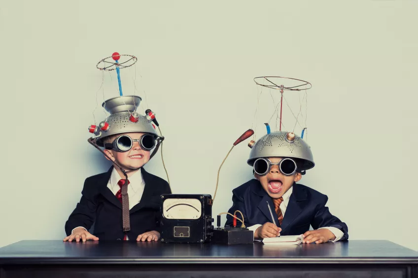 Two kids with retro-futuristic helmets on. Photo.