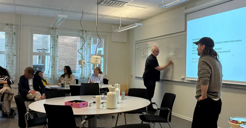 two men standing infront of white board