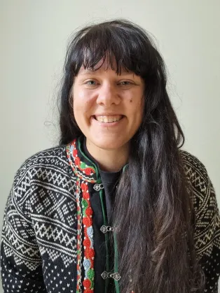 Portrait photograph of Nemi smiling at the camera. 